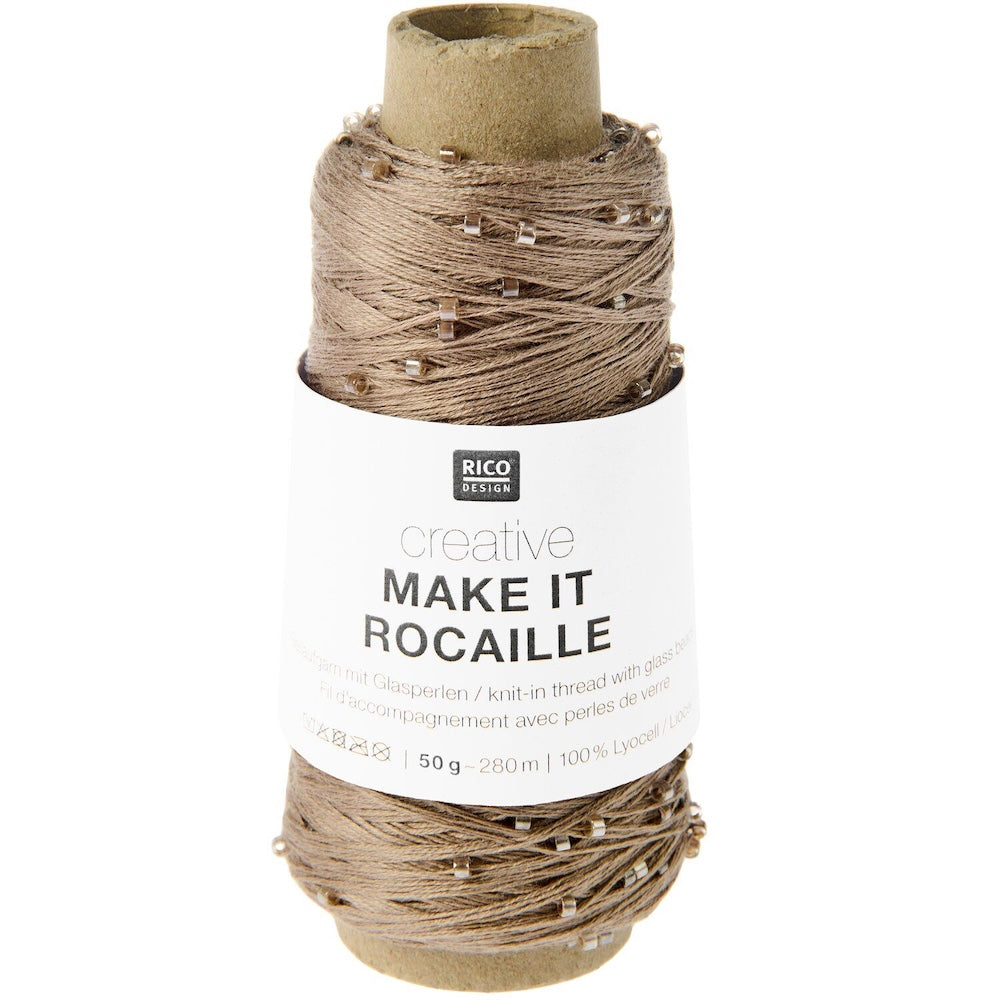 A spool of Rico Design Creative Make It Rocaille yarn thread with small rhinestones, wound on a kraft cardboard core with a white paper label.