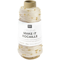 A spool of Rico Design Creative Make It Rocaille yarn thread, featuring a cream-colored thread with small gold beads and a white paper label.